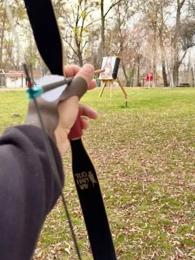 Geleneksel kıyafetiyle bir okçu, hedefe nişan alarak Kemankeş okçuluk atölyesini simgeliyor.