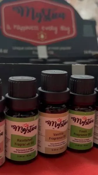 Attar usulü şişelerde geleneksel esans yağları ve kuru güller; koku atölyesi masası.